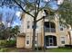 Three-story building featuring private screened balconies and lush landscaping around the property at 6100 Stevenson Dr # 202, Orlando, FL 32835