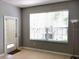 Bright living room with tile flooring, large windows offering outdoor views, and a minimalist floor lamp at 6100 Stevenson Dr # 202, Orlando, FL 32835
