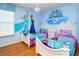themed bedroom with Frozen mural, hardwood floors, and twin beds at 7912 Golden Pond Cir, Kissimmee, FL 34747