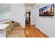 Hallway with hardwood floors leading to living area and bedroom with TV at 7912 Golden Pond Cir, Kissimmee, FL 34747