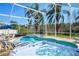 Inviting screened-in pool area with a hot tub, lounge chairs, and lush greenery for a relaxing outdoor experience at 7912 Golden Pond Cir, Kissimmee, FL 34747