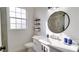 Bright bathroom featuring a modern vanity, round mirror and stylish black shelving and hardware at 8103 Coconut Palm Way # 203, Kissimmee, FL 34747