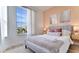 A bright bedroom featuring a plush bed, large window, and views of the neighborhood at 8103 Coconut Palm Way # 203, Kissimmee, FL 34747