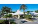 Exterior of a community clubhouse with well-manicured landscaping and ample parking at 8103 Coconut Palm Way # 203, Kissimmee, FL 34747