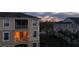 Exterior of the community building, with balconies overlooking green spaces at dusk at 8103 Coconut Palm Way # 203, Kissimmee, FL 34747