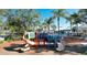 Outdoor playground with colorful slides and play equipment surrounded by mature trees at 8103 Coconut Palm Way # 203, Kissimmee, FL 34747
