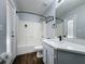 Bathroom featuring a shower/tub combo with a white shower surround, gray vanity, and wood-look flooring at 838 Sandy Ridge Dr, Davenport, FL 33896