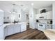 Well-lit kitchen with grey lower cabinets, white upper cabinets, stainless steel appliances and modern lighting fixture at 838 Sandy Ridge Dr, Davenport, FL 33896