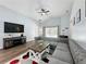 Comfortable living room featuring a vaulted ceiling, ceiling fan, wood-look flooring, and a large sofa at 838 Sandy Ridge Dr, Davenport, FL 33896
