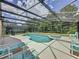 Spacious screened-in pool with lounge chairs and wooded views at 838 Sandy Ridge Dr, Davenport, FL 33896