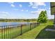 Picturesque view of the lake beyond the fenced backyard at 925 Grand Canal Dr, Poinciana, FL 34759