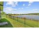 Backyard with wrought iron fence features a tranquil view of the lake at 925 Grand Canal Dr, Poinciana, FL 34759
