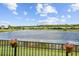 Backyard with flower pots along the fence overlooks a serene lake at 925 Grand Canal Dr, Poinciana, FL 34759