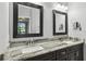 Stylish bathroom with dual sinks, granite countertops, dark cabinetry, and view into the main bedroom at 925 Grand Canal Dr, Poinciana, FL 34759