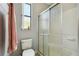Cozy bathroom with frosted glass shower door, adjacent to a toilet and window at 925 Grand Canal Dr, Poinciana, FL 34759