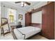 Guest room with a Murphy bed, a bedside table and a decorative mirror at 925 Grand Canal Dr, Poinciana, FL 34759