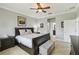 Cozy bedroom featuring a large bed, bedside tables, and adjacent doors to the en-suite bathroom and closet at 925 Grand Canal Dr, Poinciana, FL 34759