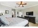 Relaxing bedroom featuring a large bed, dresser with TV, and adjacent doors to the bathroom and closet at 925 Grand Canal Dr, Poinciana, FL 34759
