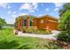 Charming single-story home with an orange exterior, manicured landscaping, and a paved walkway at 925 Grand Canal Dr, Poinciana, FL 34759