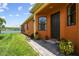 Inviting home exterior featuring a dark front door, beautiful landscaping, and a paved walkway at 925 Grand Canal Dr, Poinciana, FL 34759