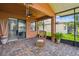 Inviting lanai with brick pavers, comfortable wicker seating, and a glimpse of the outdoor scenery at 925 Grand Canal Dr, Poinciana, FL 34759