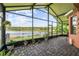 Inviting screened lanai featuring brick pavers, plants, and picturesque lake views at 925 Grand Canal Dr, Poinciana, FL 34759
