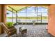 Relaxing screened-in lanai with wicker furniture overlooking a tranquil lake at 925 Grand Canal Dr, Poinciana, FL 34759