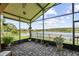 Relaxing screened lanai featuring brick pavers, potted plants, and a serene lake view at 925 Grand Canal Dr, Poinciana, FL 34759