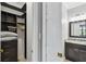 Well-organized walk-in closet leading to a bathroom with a granite vanity and mirror at 925 Grand Canal Dr, Poinciana, FL 34759