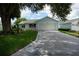 Charming single-story home with attached garage, well-manicured lawn and a long driveway at 926 Chula Ct, Lady Lake, FL 32159