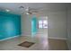 Spacious living area with tile floors, ceiling fan, teal accent wall, and views to adjacent rooms at 926 Chula Ct, Lady Lake, FL 32159
