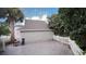 View of the backyard from the screened porch; includes garage, palm trees and a white picket fence at 934 Westpark Dr, Celebration, FL 34747