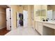 Bright bathroom featuring double sinks, tile floors, and ample storage space at 934 Westpark Dr, Celebration, FL 34747