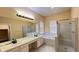 Bathroom featuring a double vanity, soaking tub, and glass-enclosed shower at 934 Westpark Dr, Celebration, FL 34747