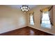 An airy bedroom with hardwood floors, a decorative chandelier, and elegant window treatments at 934 Westpark Dr, Celebration, FL 34747
