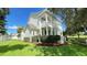 Two-story house with double balconies and a well-manicured lawn complemented by mature trees and a clear blue sky at 934 Westpark Dr, Celebration, FL 34747