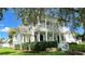 Charming two-story home featuring double balconies, white columns, and a beautifully landscaped front yard with green grass at 934 Westpark Dr, Celebration, FL 34747