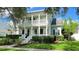 Inviting two-story home with double balconies supported by columns and manicured front yard with vibrant green lawn at 934 Westpark Dr, Celebration, FL 34747
