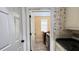 Hallway view of laundry room with machines, tile floors, floral wallpaper and utility sink at 934 Westpark Dr, Celebration, FL 34747
