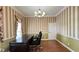 Charming office space with striped wallpaper, elegant chandelier, and large desk at 934 Westpark Dr, Celebration, FL 34747