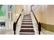Elegant staircase featuring hardwood steps, white railings, and decorative wall art at 934 Westpark Dr, Celebration, FL 34747