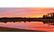 A beautiful sunset view over a pond with a reflection of the colorful sky and the nearby trees at 934 Westpark Dr, Celebration, FL 34747