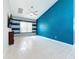 Spacious living room featuring tiled flooring, a ceiling fan, and a striking blue accent wall at 973 Corvina Dr, Davenport, FL 33897