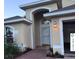 Inviting home featuring a welcoming front entrance with an arched entryway, brick path, and manicured landscaping at 117 Winchester Ln, Haines City, FL 33844