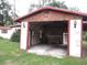 Rustic garage with shingled upper walls and red trim at 12019 Ne 212Th Street Rd, Fort Mc Coy, FL 32134