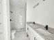 Bathroom featuring a dual granite vanity, walk-in shower, new toilet and tile floors at 1236 N Virginia Ave, Lakeland, FL 33805