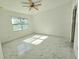 Well-lit bedroom featuring a ceiling fan, a window view and marble-style tile floors at 1236 N Virginia Ave, Lakeland, FL 33805