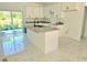 A modern kitchen featuring an island, granite countertops, and white cabinets near sliding glass doors at 1236 N Virginia Ave, Lakeland, FL 33805