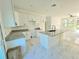 Open-concept kitchen with island, granite counters, white cabinets, and access to bright living area at 1236 N Virginia Ave, Lakeland, FL 33805
