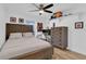 Well-lit bedroom with wood floors, a ceiling fan, a decorative shelf, and framed art at 14287 E Weymouth Run, Orlando, FL 32828